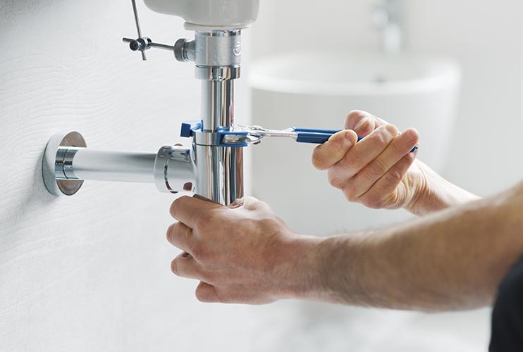 Professional plumber fixing a bathroom sink